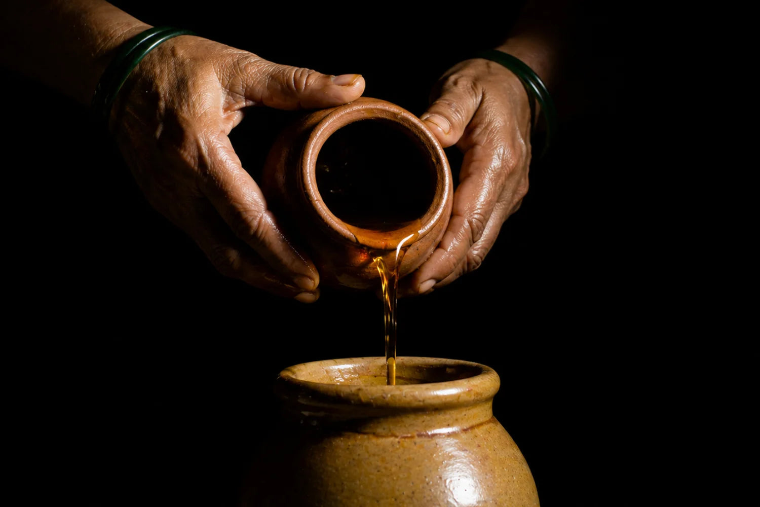 Women's hands spreading spices to sun-dry at JhaJi Store in Darbhanga — the traditional pickling craft kept alive by mothers